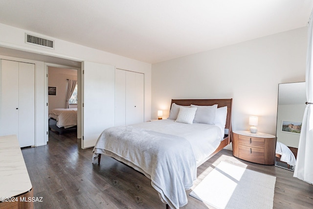 bedroom featuring multiple closets and dark hardwood / wood-style flooring