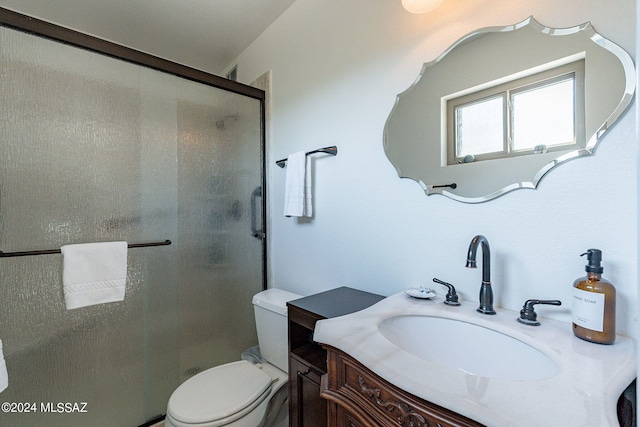 bathroom featuring vanity, an enclosed shower, and toilet