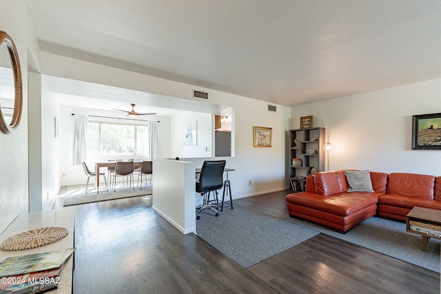 living room with ceiling fan and dark hardwood / wood-style flooring