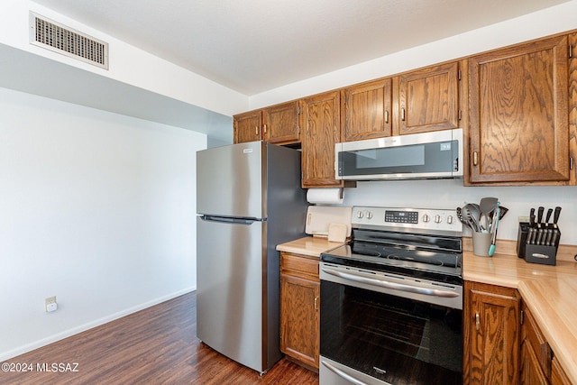 kitchen with stainless steel appliances and dark wood-type flooring