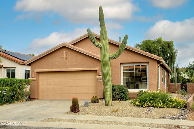 view of front of home with solar panels and a garage