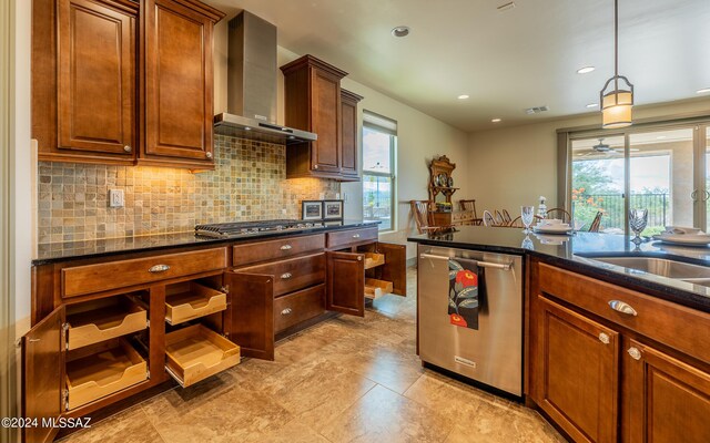 kitchen with pendant lighting, stainless steel appliances, light tile patterned floors, decorative backsplash, and wall chimney exhaust hood