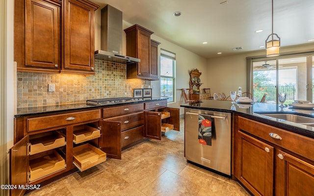 kitchen with plenty of natural light, stainless steel appliances, wall chimney range hood, and decorative backsplash