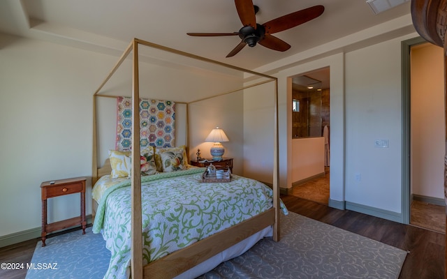 bedroom with ceiling fan, wood finished floors, visible vents, and baseboards