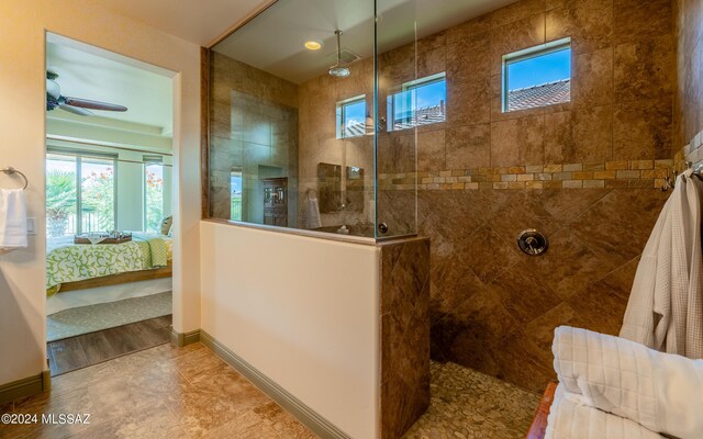 bathroom featuring ceiling fan, tiled shower, and hardwood / wood-style flooring