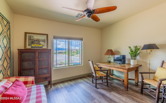 office area with a ceiling fan, wood finished floors, visible vents, and baseboards