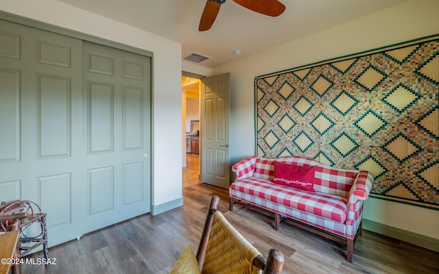 sitting room featuring visible vents, wood finished floors, baseboards, and ceiling fan