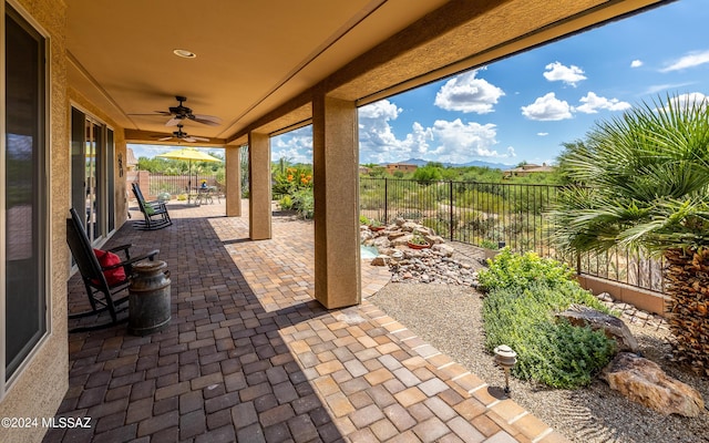 view of patio / terrace with a fenced backyard, a mountain view, and ceiling fan