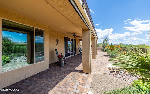 view of patio featuring a ceiling fan and fence