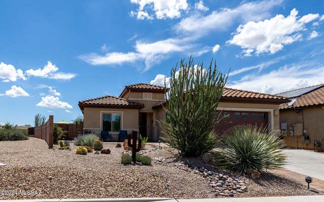 mediterranean / spanish-style home featuring solar panels and a garage