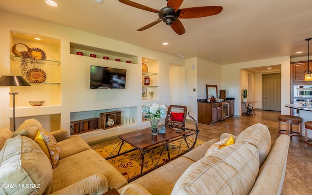 living area featuring built in features, recessed lighting, and a ceiling fan