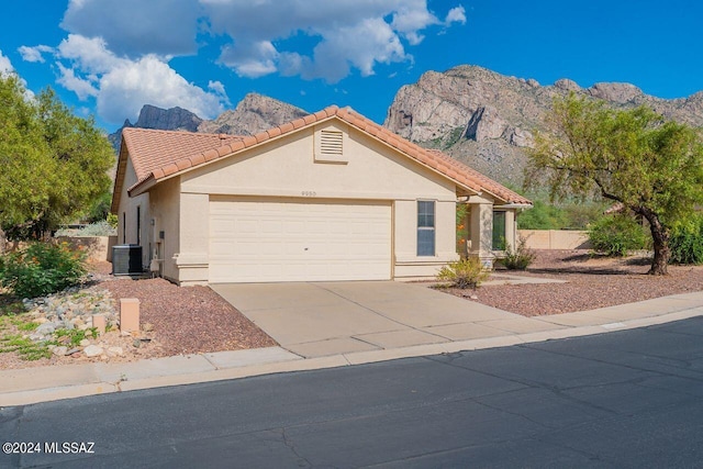 view of front of home featuring a garage, central AC, and a mountain view