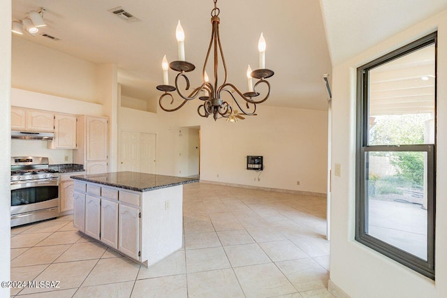 kitchen with ventilation hood, a notable chandelier, a center island, stainless steel range with gas stovetop, and light tile patterned floors