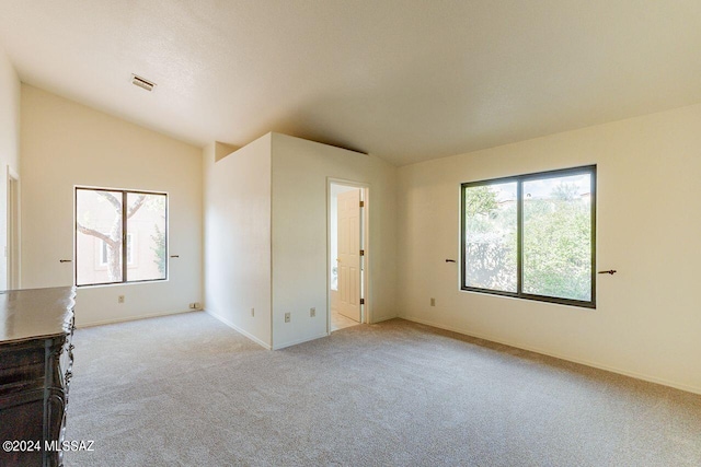 unfurnished room with vaulted ceiling and light carpet