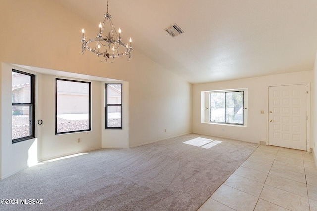 tiled spare room with a notable chandelier and lofted ceiling