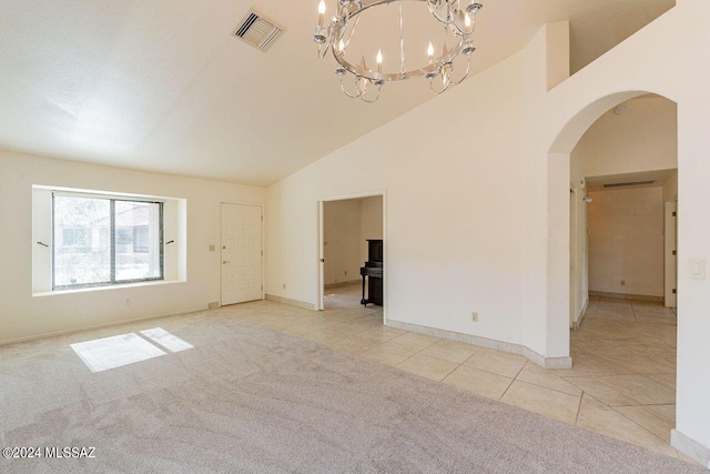 unfurnished living room with lofted ceiling, an inviting chandelier, and light colored carpet