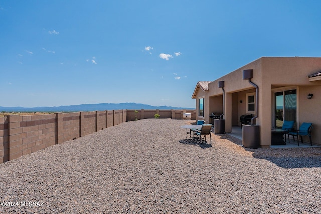 view of yard featuring a mountain view and a patio