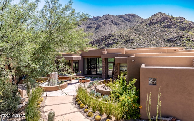 back of property featuring a mountain view and a patio