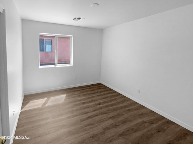 unfurnished room featuring dark wood-type flooring