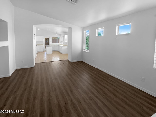 unfurnished living room featuring dark hardwood / wood-style floors and vaulted ceiling