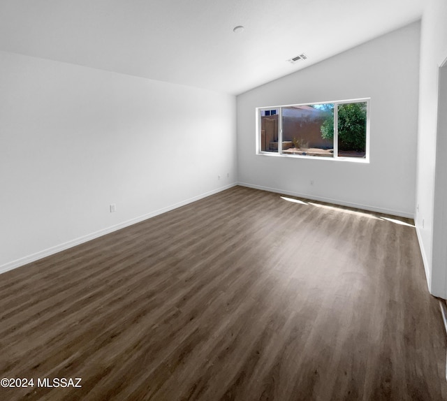 spare room with lofted ceiling and dark hardwood / wood-style floors