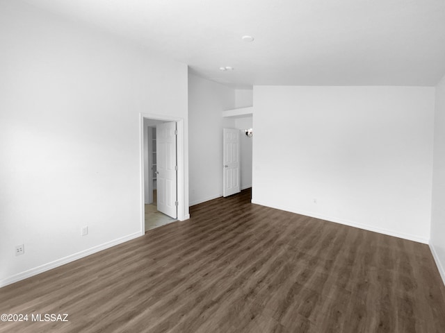 spare room with lofted ceiling and dark hardwood / wood-style flooring