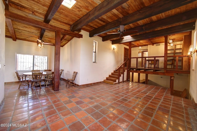 interior space featuring dark tile patterned floors, ceiling fan, and wood ceiling