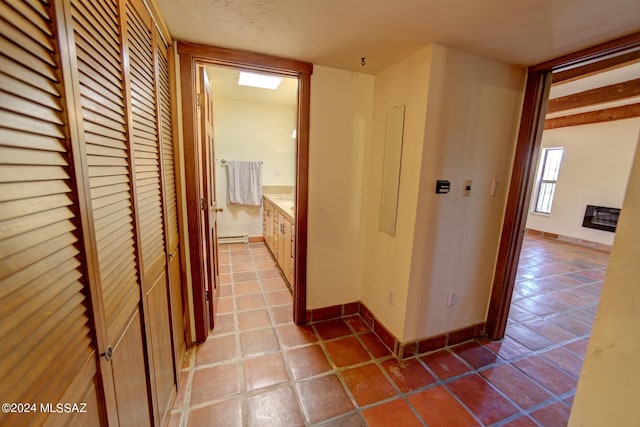 corridor with tile patterned flooring and a baseboard radiator