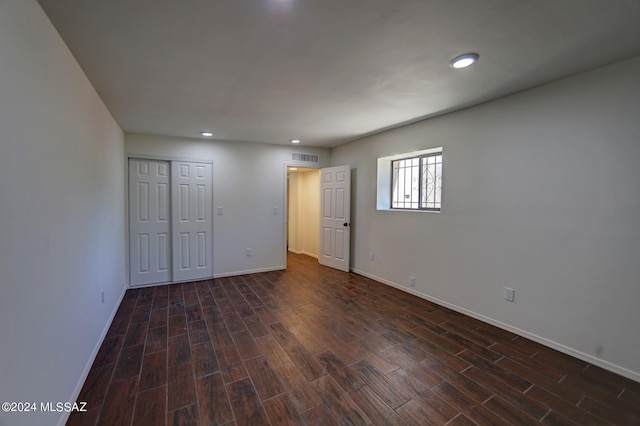 unfurnished bedroom featuring a closet and dark hardwood / wood-style flooring