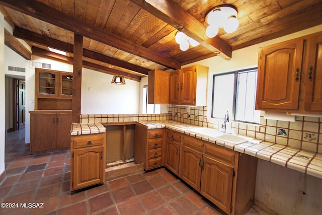 kitchen featuring backsplash, tile countertops, beamed ceiling, and wood ceiling