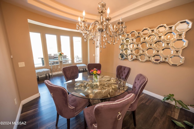 dining room with a raised ceiling, a chandelier, and dark hardwood / wood-style flooring