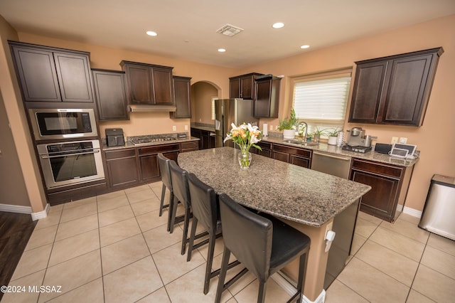 kitchen with sink, a kitchen breakfast bar, a center island, and appliances with stainless steel finishes