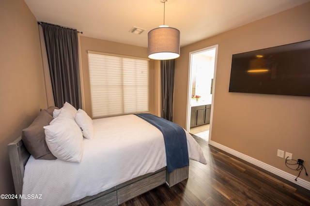 bedroom with wood-type flooring and connected bathroom