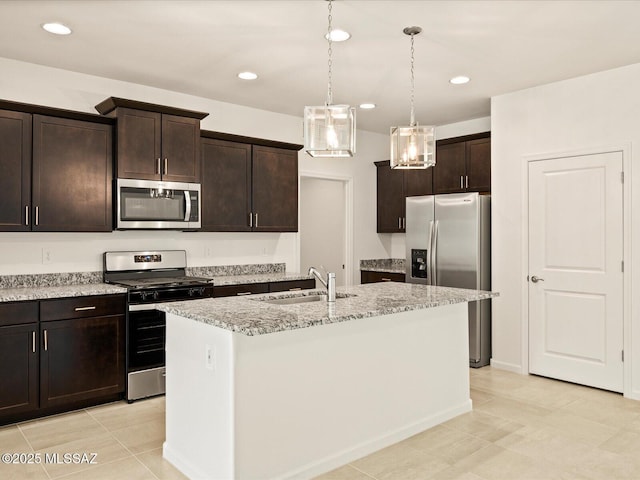kitchen featuring light tile patterned floors, appliances with stainless steel finishes, a sink, and light stone counters