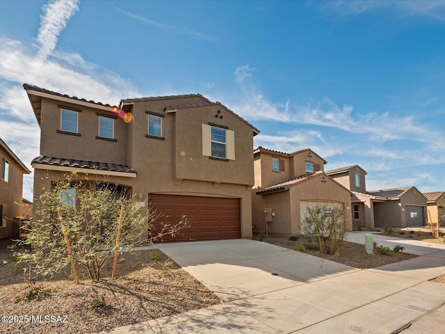 view of front of house with a tiled roof, a garage, concrete driveway, and stucco siding