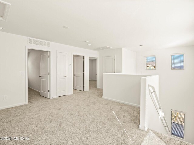 carpeted spare room with baseboards and visible vents
