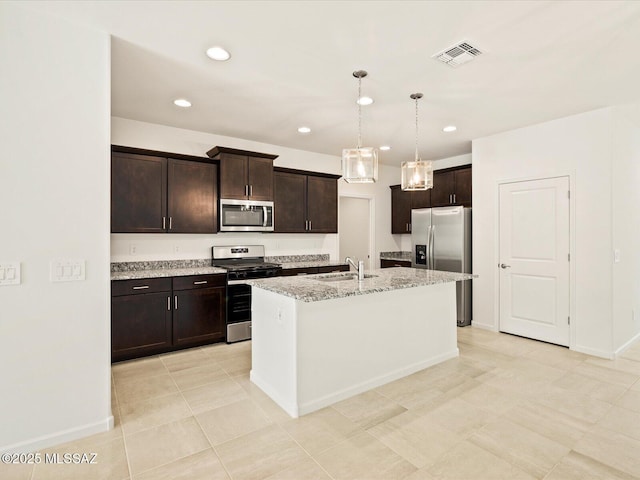 kitchen featuring visible vents, appliances with stainless steel finishes, a sink, baseboards, and light stone counters