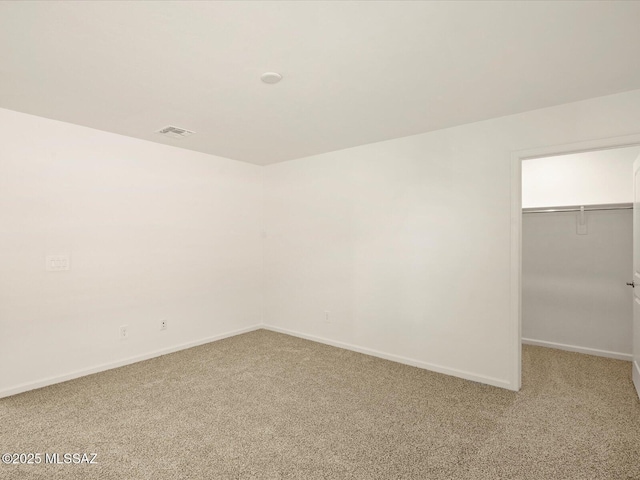 unfurnished room featuring baseboards, visible vents, and light carpet