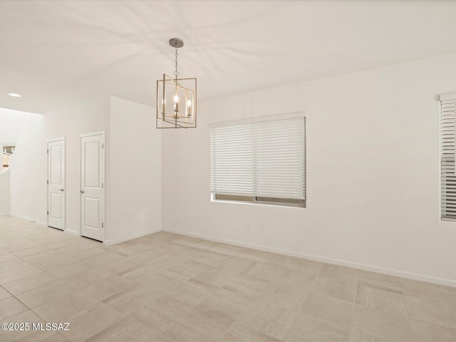 unfurnished room featuring baseboards and a notable chandelier