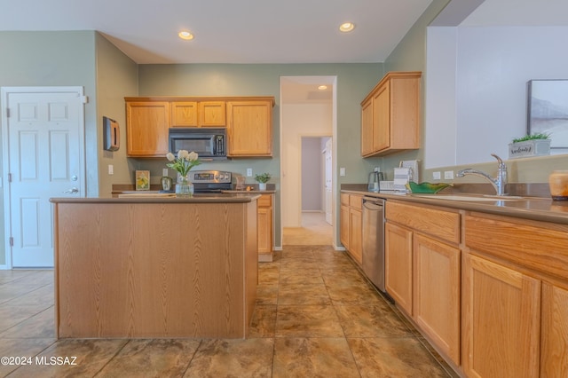 kitchen with light brown cabinets, a center island, and appliances with stainless steel finishes