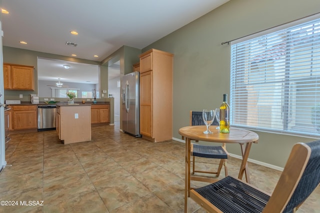 kitchen with light tile patterned floors, kitchen peninsula, and stainless steel appliances