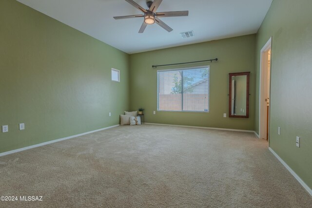 carpeted spare room featuring ceiling fan