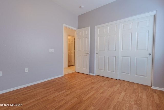 unfurnished bedroom with light hardwood / wood-style flooring and a closet