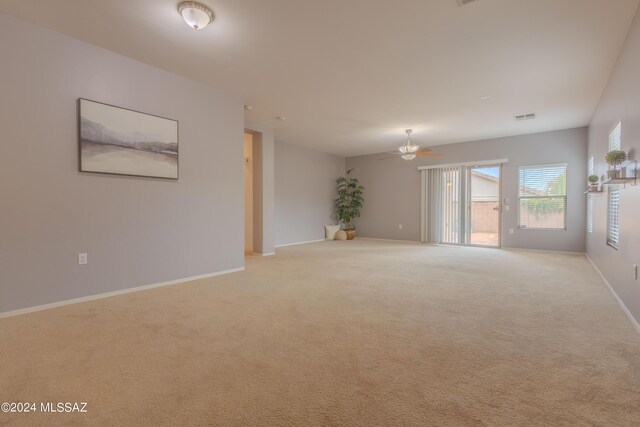 empty room featuring ceiling fan and light colored carpet