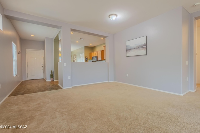 unfurnished living room featuring light colored carpet