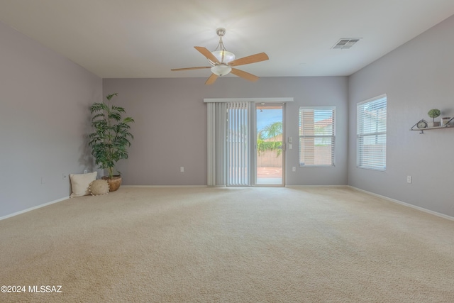 carpeted spare room featuring ceiling fan