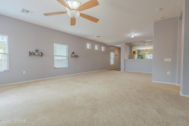 unfurnished living room with light carpet and ceiling fan