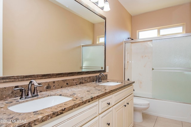 full bathroom with tile patterned flooring, toilet, bath / shower combo with glass door, and vanity