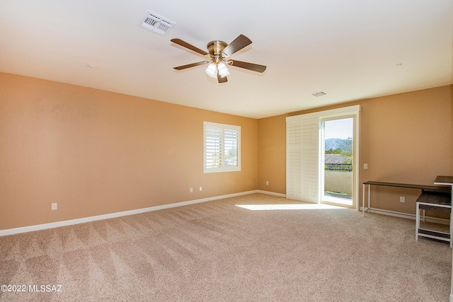 carpeted spare room with ceiling fan