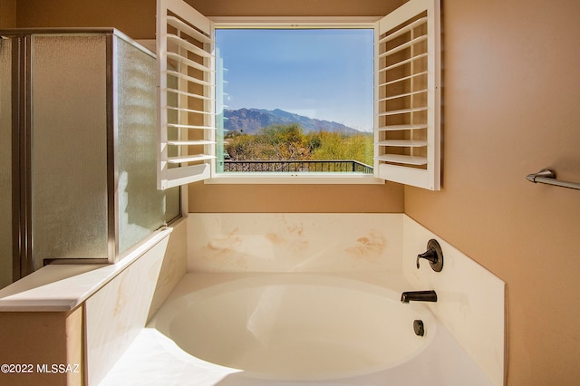 bathroom featuring a bathing tub and a mountain view